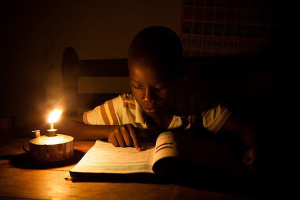 boy reading in candle light