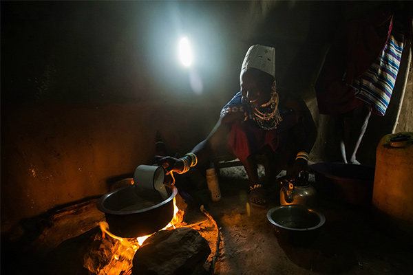 man in hut cooking on fire